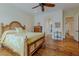 Bedroom with hardwood floors, ceiling fan, and a comfortable looking bed with yellow and white patterned comforter at 11477 Timber Mountain Ave, Las Vegas, NV 89135