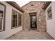 Elegant home entrance with a stone facade, large windows, and a modern front door at 11477 Timber Mountain Ave, Las Vegas, NV 89135