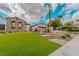 Inviting home exterior with manicured landscaping, artificial grass and a stone facade with a bench at 11477 Timber Mountain Ave, Las Vegas, NV 89135