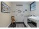 Bright laundry room featuring modern appliances, black and white floors, and natural light from a window at 11477 Timber Mountain Ave, Las Vegas, NV 89135