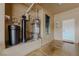 Spacious utility room includes water heater and water filtration system and tan walls at 11477 Timber Mountain Ave, Las Vegas, NV 89135