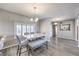 Modern dining room with grey walls, hardwood floors, a white table, and a light fixture at 1157 Morning Sun Way, Las Vegas, NV 89110