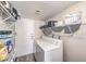 Bright laundry room featuring a white washer and dryer and wire shelving for convenient storage at 1157 Morning Sun Way, Las Vegas, NV 89110