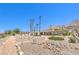 Desert landscaped yard with rock border and small grass area and mountain views at 1157 Morning Sun Way, Las Vegas, NV 89110