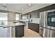 Well-lit kitchen featuring stainless steel appliances, island sink, and tile flooring at 1275 Ice Park St # 101, Las Vegas, NV 89135
