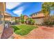Inviting backyard featuring a covered patio, lush lawn, and low-maintenance desert landscaping at 1420 Gilbert Creek Ave, North Las Vegas, NV 89031