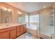 En-suite bathroom features double sinks, a soaking tub, and a walk-in shower with glass doors at 1420 Gilbert Creek Ave, North Las Vegas, NV 89031