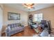 Cozy bedroom with a ceiling fan, hardwood floors, and a comfortable sitting area at 1420 Gilbert Creek Ave, North Las Vegas, NV 89031