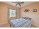 Comfortable bedroom with a ceiling fan, neutral carpet, and natural lighting at 1420 Gilbert Creek Ave, North Las Vegas, NV 89031