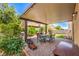 Covered patio featuring an outdoor dining area and grill, surrounded by lush greenery at 1420 Gilbert Creek Ave, North Las Vegas, NV 89031