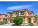 Home featuring a two-car garage, desert landscaping, shuttered windows, and an arched front door entrance at 1420 Gilbert Creek Ave, North Las Vegas, NV 89031