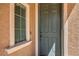 Home's front door featuring a green-colored door, a window, and textured walls at 1420 Gilbert Creek Ave, North Las Vegas, NV 89031