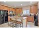 Eat-in kitchen features granite counters, stainless appliances, a black refrigerator, and seating at the island at 1420 Gilbert Creek Ave, North Las Vegas, NV 89031