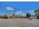 View of expansive backyard with gravel, partially fenced, and view of the home's rear at 1560 Arabian Dr, Henderson, NV 89002