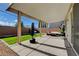 A backyard features covered patio with outdoor seating, green turf, barbecue, and punching bag at 1637 Harvest Pecan Ct, Las Vegas, NV 89108