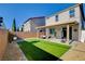 Spacious backyard with covered patio, artificial turf, barbecue, and low-maintenance landscaping at 1637 Harvest Pecan Ct, Las Vegas, NV 89108
