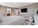 Comfortable main bedroom features a luxurious bed, view into bath, and mounted television at 1637 Harvest Pecan Ct, Las Vegas, NV 89108