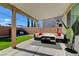 A covered patio with an outdoor seating area, green turf, and barbecue at 1637 Harvest Pecan Ct, Las Vegas, NV 89108
