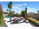 Lush backyard featuring a sparkling pool, outdoor seating, manicured landscaping, and towering palm trees at 188 Carthage St, Henderson, NV 89074