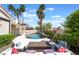 Beautiful backyard with a pool, a seating area with white couches and palm trees at 188 Carthage St, Henderson, NV 89074