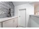 Hallway with modern gray tiled accent wall, white door, and neutral cabinets at 188 Carthage St, Henderson, NV 89074