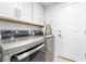 Updated laundry room features modern washer and dryer, white cabinetry, and a convenient ironing board at 188 Carthage St, Henderson, NV 89074