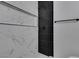 A modern bathroom with white marble-style tiles and a black-tiled shower niche and wall at 212 View Dr, Las Vegas, NV 89107