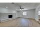 A spacious living room featuring light wood floors, a white brick fireplace, and a ceiling fan at 212 View Dr, Las Vegas, NV 89107