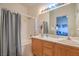 Bathroom with a double sink vanity, large mirror, and shower, leading to view to bedroom at 2920 Riarosa Ct, North Las Vegas, NV 89086