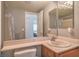 Bright bathroom featuring a single sink vanity, large mirror and shower with decorative curtain at 2920 Riarosa Ct, North Las Vegas, NV 89086
