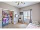 This bedroom features a ceiling fan, window with blinds, mounted television and organized closet at 2920 Riarosa Ct, North Las Vegas, NV 89086