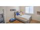 Minimalist bedroom with a twin bed, large window, and neutral tones, offering a calming retreat at 2920 Riarosa Ct, North Las Vegas, NV 89086
