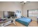 A bright bedroom with a sloped ceiling, a blue comforter, large window and a desk setup at 2920 Riarosa Ct, North Las Vegas, NV 89086