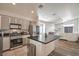 Open-concept kitchen with stainless steel appliances and a kitchen island flowing into a living space with modern furniture at 2920 Riarosa Ct, North Las Vegas, NV 89086