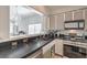 Kitchen features dark countertops, stainless steel appliances, and a view into another room with a chandelier at 2920 Riarosa Ct, North Las Vegas, NV 89086