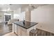 Open concept: Kitchen island with black countertop and seating overlooking the living area, filled with natural light at 2920 Riarosa Ct, North Las Vegas, NV 89086