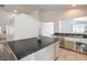 Bright kitchen with an island featuring a black countertop and white cabinets, complemented by stainless steel appliances at 2920 Riarosa Ct, North Las Vegas, NV 89086