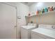 Clean laundry room features washer and dryer, ample shelving and a closed door at 2920 Riarosa Ct, North Las Vegas, NV 89086