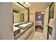 Modern bathroom featuring double sinks, a large framed mirror, and a view into the bedroom at 2926 E Eldorado Ln, Las Vegas, NV 89120
