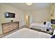 Bright bedroom with two beds, wood dresser and TV mounted on the wall at 2926 E Eldorado Ln, Las Vegas, NV 89120