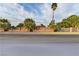 View of the property with palm trees, red roofing and a decorative, light brick perimeter fence at 2926 E Eldorado Ln, Las Vegas, NV 89120