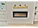 Modern electric fireplace with white wood paneling and stylish decorative shelving at 2926 E Eldorado Ln, Las Vegas, NV 89120