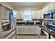 Well-equipped kitchen with stainless steel refrigerator, white cabinets, and modern appliances at 2926 E Eldorado Ln, Las Vegas, NV 89120