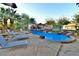 Inviting pool area featuring lounge chairs, a rock waterfall, and meticulous landscaping at 2926 E Eldorado Ln, Las Vegas, NV 89120