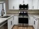 Kitchen featuring stainless steel appliances, white cabinets, and granite countertops at 3005 Treasure Island Rd, Las Vegas, NV 89128