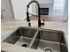 Close up of Kitchen sink and faucet, with granite countertops and view into living space at 3005 Treasure Island Rd, Las Vegas, NV 89128