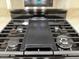 Close up of a stainless steel gas stove top with a black griddle at 3005 Treasure Island Rd, Las Vegas, NV 89128
