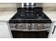 Close-up of stainless steel gas stovetop and oven with white cabinets and hardware at 3005 Treasure Island Rd, Las Vegas, NV 89128