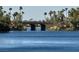 Scenic view of a lake with palm trees and an arched stone bridge in the distance on a clear day at 3005 Treasure Island Rd, Las Vegas, NV 89128