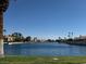 Beautiful waterfront view surrounded by lush greenery, palm trees, and nearby houses, creating a community setting at 3005 Treasure Island Rd, Las Vegas, NV 89128